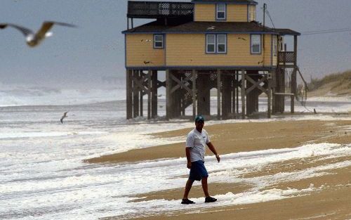 KITTY HAWK - Ondanks de naderende orkaan Isabel waagt deze eenzame wandelaar zich bij Kitty Hawk in North Carolina nog aan het strand. - Foto EPA