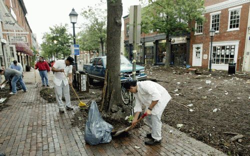 ALEXANDRIA â€“ Medewerkers van winkels en restaurants in Alexandria (Virginia), even buiten Washington D.C., ruimen de rommel op die de rivier de Potomac heeft achtergelaten. De rivier trad vrijdag buiten haar oevers als gevolg van de orkaan Isabel, die d