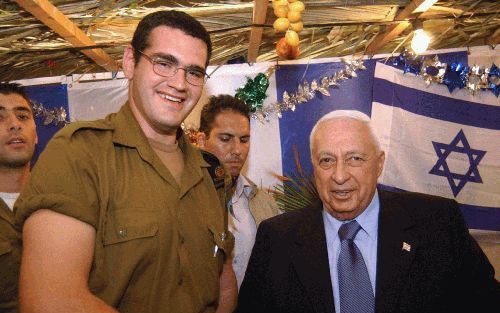 JERUZALEM â€“ De IsraÃ«lische premier Ariel Sharon verwelkomt een geÃ¯mmigreerde soldaat op zijn Sukka viering in zijn residentie in Jeruzalem. Bij de viering van het Loofhuttenfeest herdenken de Joden de veertigjarige woestijnreis uit Egypte naar het bel