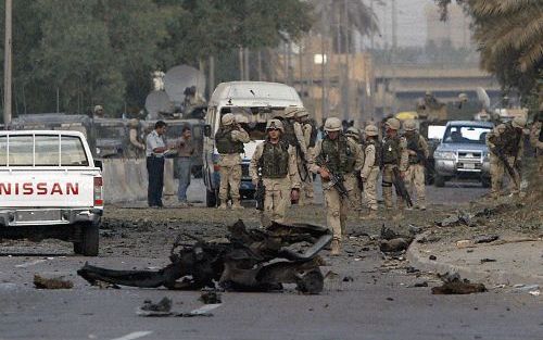 BAGDAD - Amerikaanse militairen inspecteren de wrakstukken van een voertuig na een explosie bij de Turkse ambassade in de Iraakse hoofdstad. Bij de zelfmoordaanslag van dinsdag kwam alleen de dader om het leven. - Foto EPA