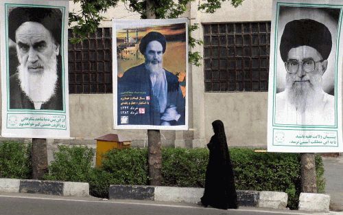 TEHERAN - De strenge blik van ayatollah Khomeini (l.) is nog overal in het straatbeeld in Teheran aanwezig. - Foto EPA