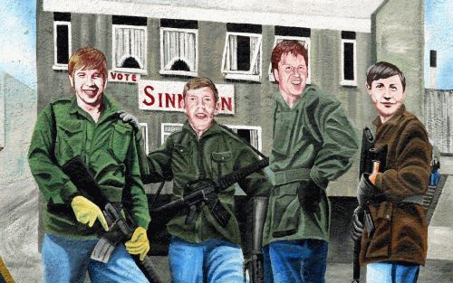 BELFAST â€“ Een muurschildering in het westen van de Noord Ierse hoofdstad Belfast toont gewapende leden van het Ierse Republikeinse Leger (IRA) voor een kantoor van Sinn Fein, de politieke tak van de afscheidingsbeweging. Foto EPA