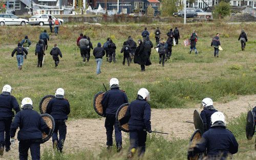 AMSTERDAM â€“ De mobiele eenheid voert charges uit tegen linkse actievoerders in Amsterdam. Achter het centraal station kwam het zaterdagmiddag tot rellen tussen linkse en rechtse extremisten. De antifascisten voerden actie tegen een demonstratie van het 