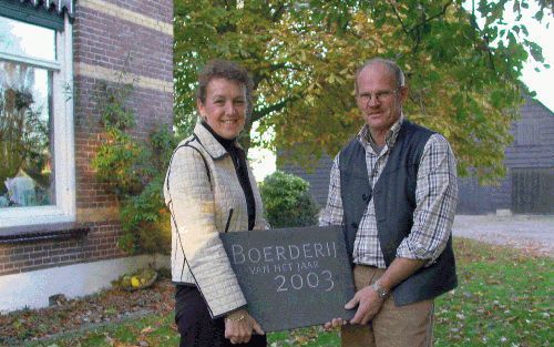 ZONNEMAIRE - Het echtpaar Van der Bijl met de gevelsteen die ze kregen van de Stichting 2003 Jaar van de Boerderij. Hun hoeve is zaterdag uitgeroepen tot boerderij van het jaar. Van der Bijl: „Het gaat ons niet om de prijs. We onderhouden de boerderij om 