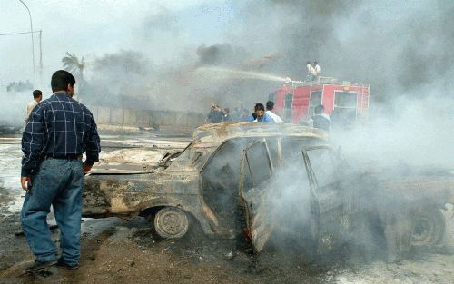 NASIRIYAH â€“ Woensdag was het chaos alom in het Zuid Iraakse Nasiriyah, waar een truck vol met explosieven tot ontploffing kwam bij de Italiaanse VN post. Tot dusver werden 27 doden geteld. Deze Irakees kijkt naar het brandende wrak van een auto. Foto EP