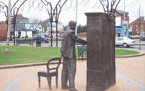 BELFAST - Een bronzen voorstelling in Belfast toont de jongvolwassen C. S. Lewis: hij opent de deur van een kast en tuurt naar de geheimzinnige wereld die zich achter die deur voor hem ontvouwt, terwijl zijn linkerhand leunt op de stoelleuning achter hem.