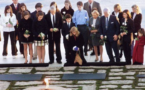 ARLINGTON - De door familieleden omringde Caroline Kennedy Schlossberg (m.) knielde zaterdag bij het graf van haar vader, de voormalige Amerikaanse president John F. Kennedy, die veertig jaar geleden werd vermoord. - Foto EPA