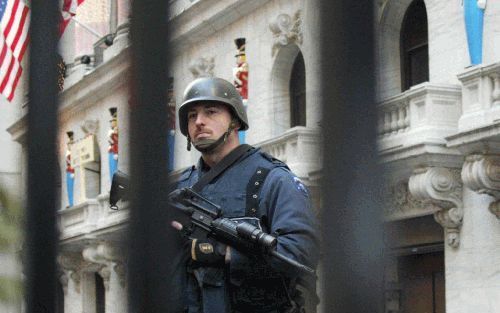 NEW YORK â€“ Een politieagent stond maandag op wacht bij het beursgebouw op Wall Street in New York. In de Verenigde Staten is het terreuralarm zondag op oranje gezet. De inwoners van het land is gevraagd alert te zijn. Foto EPA