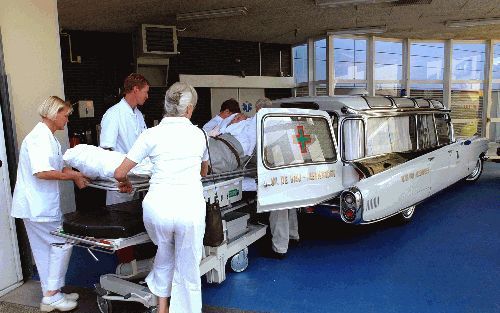 ASSEN â€“ Op 14 augustus dit jaar haalde Martin de Vrij met een Cadillac ambulance uit 1959 zijn schoonvader Gerrit de Vries uit het ziekenhuis in Assen. Op de foto staat De Vrij achter de openstaande autodeur. Derde van links zijn echtgenote Tinie de Vri