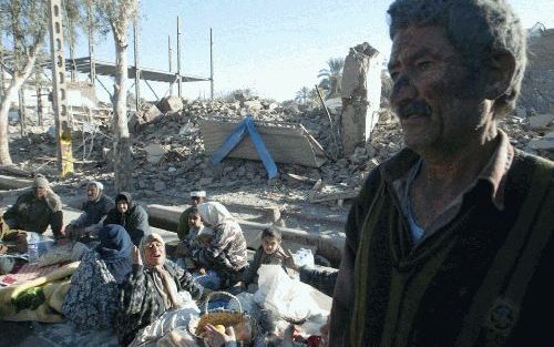 BAM â€“ Inwoners van de door een aardbeving getroffen Iraanse stad Bam zitten tussen de puinhopen van hun woningen.&#61559;Foto EPA