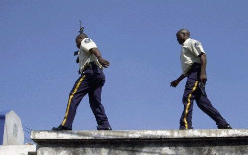 PORTâ€“AUâ€“PRINCE - Politie zoekt pro-regering demonstranten die rellen uitlokte tijdens een anti-regeringsbetoging. Foto AFP