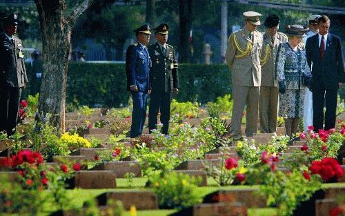 KANCHANABURI â€“ Koningin Beatrix en prins Willem Alexander stonden woensdag bij het graf van J. M. Monod de Froidville (inzet), de vader van de ceremoniemeester van de vorstin, uiterst rechts op de foto. De vorstin en haar zoon legden woensdag een krans 