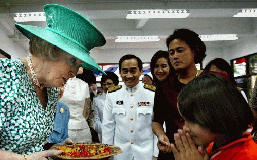 BANGKOK â€“ Een meisje uit het Kredtrakarn Protection and Occupational Development Center bood koningin Beatrix gisteren tijdens het staatsbezoek aan Thailand een schaal met fruit van marsepein aan. Het centrum vangt ontspoorde meisjes en slachtoffers van