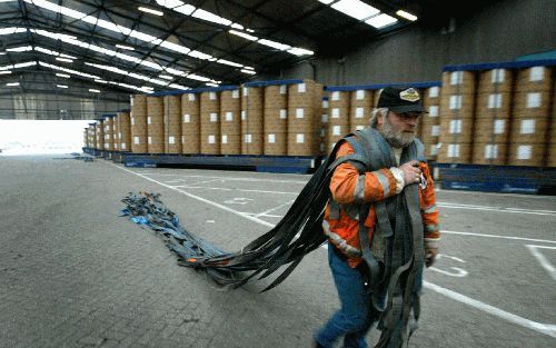 ROTTERDAM â€“ Een arbeider versleept spanbanden in een loods in de haven van Rotterdam. Foto ANP