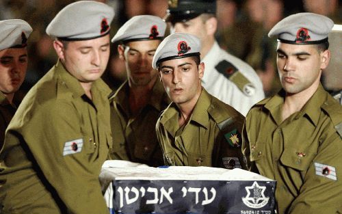 LOD â€“ IsraÃ«lische soldaten dragen de kist met het lichaam van sergeant Adi Avitan tijdens een officiÃ«le herdenkingsdienst. IsraÃ«l ontving donderdag van de militante Libanese groep Hezbollah de stoffelijke resten van drie in Libanon gedode militairen.