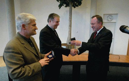 KAMPEN â€“ Kerkhistoricus prof. dr. F. van der Pol (l.) en archivaris en onderzoeker drs. J. van Gelderen (m.) ontvingen beiden vrijdag van wethouder R. de Boer de zilveren legpenning van de stad Kampen. De ontvangst in het stadhuis luidde het jubileumjaa