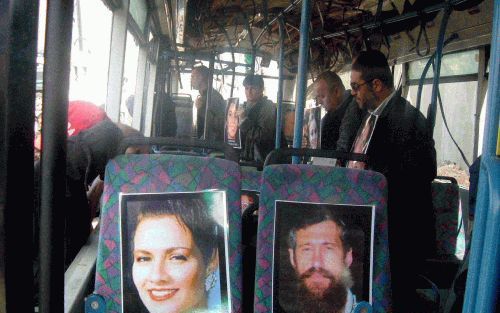 JERUZALEM â€“ Nabestaanden van slachtoffers die omkwamen bij de Palestijnse zelfmoordaanslag afgelopen zondag op een bus in Jeruzalem zetten foto’s van hun familieleden op de zitplaatsen van het totaal vernielde voertuig. De bus werd in het kader van de h