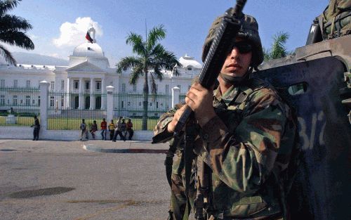 PORTâ€“AUâ€“PRINCE - Soldaten van het leger van de Verenigde Staten staan op wacht bij het Nationale Paleis in Port-au-Prince. Foto: EPA