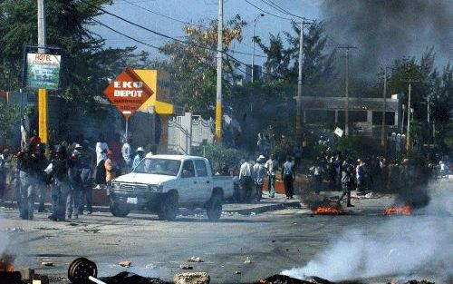 PORT AU PRINCE â€“ Rookwolken stijgen op van een industrieterrein in de HaÃ¯tiaanse hoofdstad Port au Prince. Ondanks de aanwezigheid van buitenlandse troepen duurt het geweld in HaÃ¯ti nog altijd voort. Foto EPA