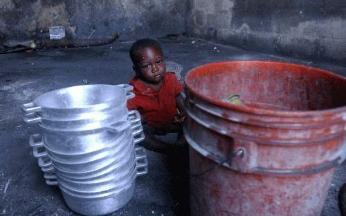 PORT-AU-PRINCE - Een HaÃ¯tiaanse peuter zit in een kazerne in de hoofdstad Port-au-Prince. Langzaam maar zeker keert de rust weer in het door burgeroorlog geteisterde land. Inmiddels zijn hulpverleners begonnen de vele ontheemden, die voor het geweld op d