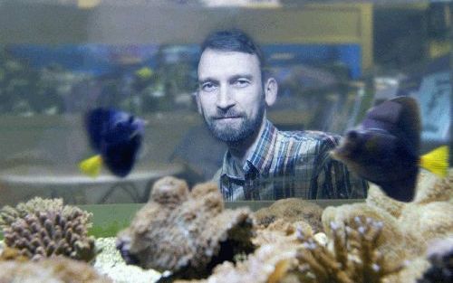 HAZERSWOUDE â€“ A. Verloop achter een van de aquariums in zijn winkel. Hoewel mensen wat terughoudender zijn met hun uitgaven, zijn vissen en hun toebehoren volgens hem meer dan waar die het alleen als luxe goed doet. „Wij profiteren ervan dat mensen meer