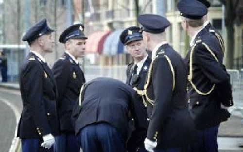 DEN HAAG: Politieagenten staan dinsdag in Den Haag langs de route van de uitvaartstoet van prinses Juliana wat te praten om de tijd te doden. Foto ANP