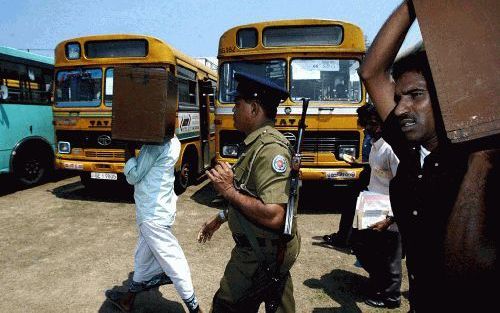 COLOMBO â€“ Ambtenaren sjouwen met stembussen door de straten van de Srilankaanse hoofdstad Colombo om iedereen de kans te geven vrijdag zijn of haar stem uit te brengen. Foto EPA