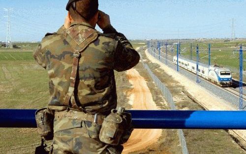 GUADALAJARA â€“ Een Spaanse militair houdt het spoor in de buurt van Guadalajara in de gaten. De autoriteiten hebben de veiligheidsmaatregelen in het hele land aanzienlijk verscherpt, uit angst voor aanslagen tijdens de paasdagen. Foto EPA