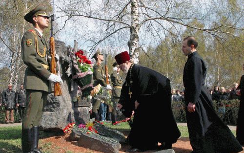 MINSK â€“ Een Russisch orthodoxe en een katholieke priester leggen bloemen bij het Tsjernobyl gedenkteken in Minsk. Maandag was het achttien jaar geleden dat de ramp met de kerncentrale plaatshad. Foto EPA