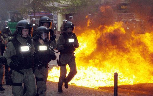 BERLIJN - Leden van de oproerpolitie rennen langs een brandende blokkade in het centrum van Berlijn. Evenals in voorgaande jaren liep de 1-meiviering in de Duitse hoofdstad uit op rellen tussen jeugdige betogers en de politie. - Foto EPA