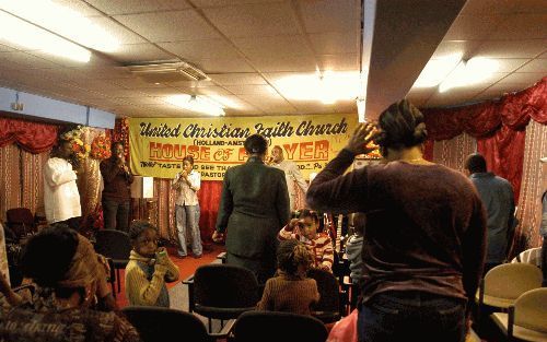 AMSTERDAM - Een kleine, benauwde ruimte. De snoeiharde gospelmuziek is buiten goed te horen. Praise the Lord. Hier komt de United Christian Faith Church samen â€“ en niet alleen zondags. Foto Paul van Weel