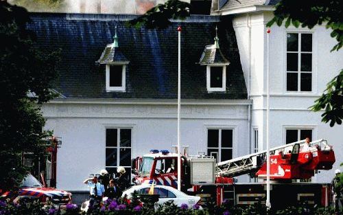 DEN HAAG â€“ Rook komt uit het dak van het Catshuis. De ambtswoning van premier Balkenende is zaterdag aanzienlijk beschadigd door een grote brand. Daarbij kwam een schilder om het leven. Foto ANP