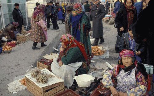 ASJCHABAD â€“ Straatverkopers in Turkmenistan proberen hun waren te slijten, terwijl een politieagent een oogje in het zeil houdt. Foto Hollandse Hoogte