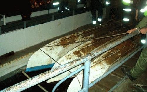 WENEN - Hulpverleners staan naast de omgeslagen boot in HinterbrÃ¼hl. Maandag kwamen vijf mensen om op een ondergronds meer in Oostenrijk. Foto EPA