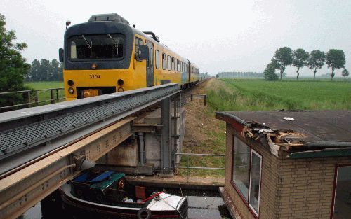 BEDUM â€“ Een woonboot ligt met forse schade bij de spoorbrug over het Boterdiep bij het Groningse Bedum. Een trein botste woensdag op de boot. Foto FBF.NL