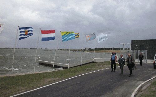 WILHELMINADORP â€“ Staatssecretaris Schultz van Haegen nam woensdag tijdens een vliegende storm het doorlaatmiddel in de Zandkreekdam bij Wilhelminadorp in gebruik. Het doorlaatmiddel, dat zich onder de dam bevindt, wordt vanuit het zwarte gebouw bediend.