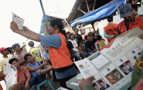 JAKARTA â€“ Een Indonesische verkiezingsfunctionaris houdt een stembiljet omhoog nadat het stemmen in Jakarta is afgelopen. Meer dan 80 procent van de 153 kiesgerechtigden in IndonesiÃ« bracht gisteren voor het eerst direct een stem uit in de presidentsve