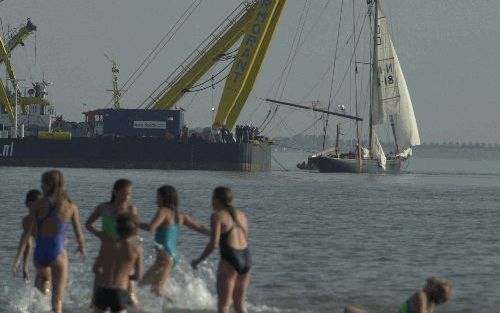 VLISSINGEN - Kinderen ravotten in het water van de Westerschelde, terwijl bergers het Noorse jacht de Mohohawk II boven water halen. Het zeiljacht zonk in de nacht van zondag op maandag na een aanvaring met een vissersschip. Het jacht wordt naar Vlissinge