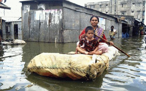 AGARTALA/DHAKA - Beelden van de moesson in India (jongen aan waterpomp in Agartala) en Bangladesh. De hevige regenval leidt in AziÃ« tot grote overstromingen. Grote delen van Dhaka, de hoofdstad van Bangladesh, staan onder water. - Foto’s EPA