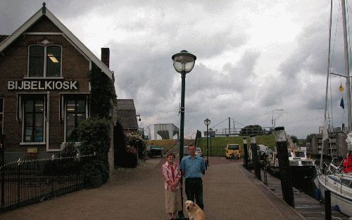 OUD BEIJERLAND â€“ Dick en Rita Lagerwerf voor hun Bijbelkiosk Het Levende Woord. „De praktijk is niet dat toeristen, zo hup vanaf de boot, naar ons toekomen om een Bijbel aan te schaffen. Zo hongerig zijn de mensen helaas niet.” Foto RD