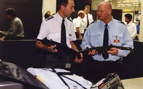 EDE â€“ Politie en douane nemen regelmatig nepwapens in beslag die bedrieglijk echt op gewone wapens lijken. Foto: een douanier (l.) en een lid van de marechaussee vergelijken op Schiphol een echt en een nagemaakt wapen. Foto ANP