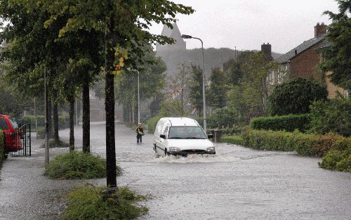 STIENS â€“ Een automobilist baande zich woensdag een weg door ondergelopen straten in het Friese Stiens. Met name in Friesland en in het Westland viel gisteren veel regen.