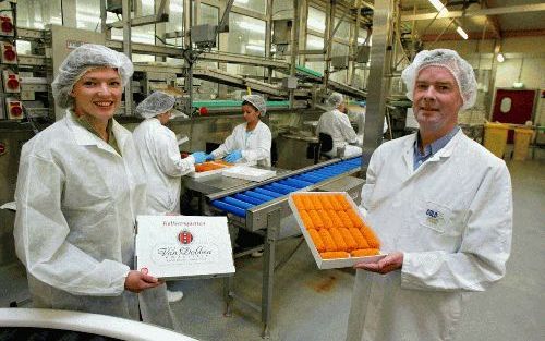 OOSTZAAN â€“ Van de acht productielijnen van Cold Food rollen jaarlijks 18 miljoen Kwekkeboom kroketten, 22 miljoen Van Dobbens en 10 miljoen van de Laan variant. Op de foto de inpaklijn van Van Dobben met Moniek Provoost (l.) en directeur Sjoerd Zwanenbu