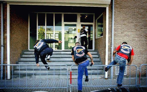 AMSTERDAM - Leden van de Hells Angels springen over het hek voor de extra beveiligde zaal van de rechtbank in Amsterdam. Daar verschijnen vandaag en morgen in totaal dertien leden van de Limburgse motorclub de Nomads. Ze worden er onder meer van verdacht 