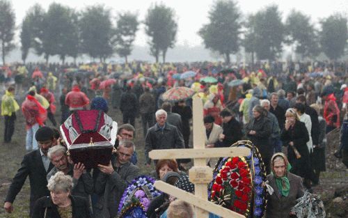 BESLAN â€“ Inwoners van het Noord Ossetische Beslan dragen een slachtoffer van het gijzelingsdrama ten grave. Het kerkhof werd maandag bevolkt door rouwende mensen. Foto EPA