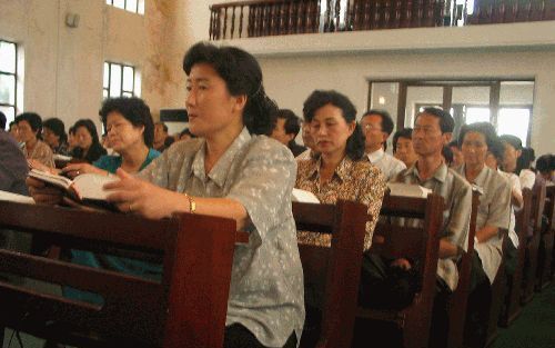 PYONGYANG - Een kerkdienst in\'Pyongyang\'. Volgens ingewijden zijn de kerkgangers tevoren van huis opgehaald om als gemeente te fungeren. Aan alles is gedacht om de dienst zo levensecht mogelijk te maken. Voor in de kerk staat een zangkkoor opgesteld, de