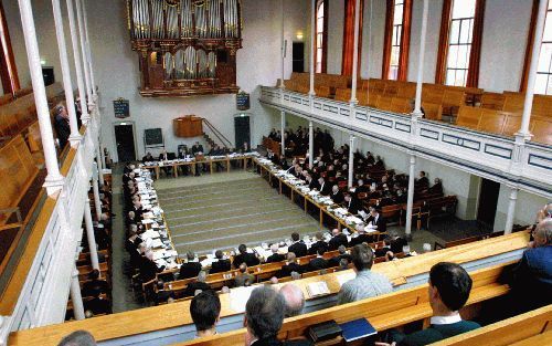 Beeld van een synodevergadering van de Gereformeerde Gemeenten. Ds. A. Moerkerken durft geen uitspraak te doen over hoe zijn kerkverband er over veertig jaar uit zal zien. „ Waar ik wel tot in mijn nieren van overtuigd ben, is dit: God zal Zijn Kerk op aa