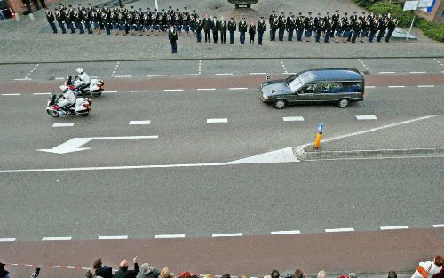 ENSCHEDE â€“ Politieagenten vormden woensdag voor het hoofdbureau van de politie in Enschede een erehaag bij het passeren van de begrafenisstoet van hun collega Jan Wind. De vorige week doodgeschoten agent werd gisteren in Usselo gecremeerd. Foto ANP