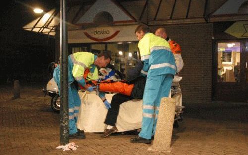 DELFT â€“ Twee verpleegkundigen tillen een 51-jarige man op een brancard bij een supermarkt in Delft. De man werd woensdag mishandeld door twee personeelsleden van de winkel. Zij gingen ervan uit dat hij iets had gestolen. Volgens de politie staat dit eve