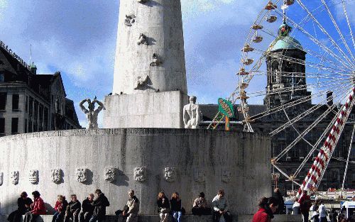 AMSTERDAM â€“ Zittend op het nationale monument op de Dam in Amsterdam genieten de mensen van het najaarszonnetje. Een paar meter verderop staat een deftige heer even pauze te houden op het trottoir voor z’n winkel. Hij rookt een sigaret terwijl hij kijkt